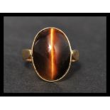 A hallmarked 14ct gold and tigers eye ring, set with a tigers eye cabochon with stylised