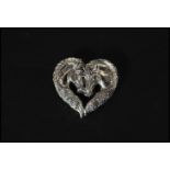 A sterling silver heart shaped brooch / necklace pendant in the form of two horses having pin to