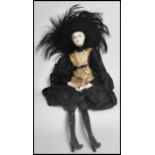 An early 20th century Art Deco French Boudoir cabaret doll. The ceramic head painted in a