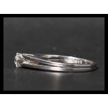 A 14ct white gold and diamond solitaire ring. The diamond being prong set in a raised mount having