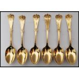 A set of six gilt silver hallmarked tea spoons with scrolled terminals with acanthus leaf detailing.