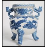 A 20th century Chinese ceramic blue and white prayer bowl raised on tripod legs with twin dragon