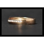 A hallmarked 9ct gold and diamond band ring set with 15 round cut diamonds totalling approximately