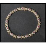 A hallmarked 9ct white and yellow gold ruby and diamond bracelet set with gold kiss and cluster