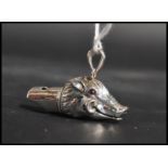 A sterling silver novelty whistle in the form of a boars head with bail loop atop. Weighs 19