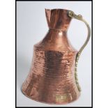 A 19th century Dallah Arabic copper coffee pot having a brass shaped handle. Measures 31cms high.