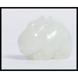 A 20th century Chinese  white jade carving of a rabbit, hunched on all fours measuring 4.5 cm.