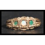 A hallmarked 9ct gold opal and peridot ring. The central opal flanked by two green peridot stones