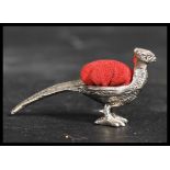 A sterling silver pin cushion in the form of a pheasant with a red baize cushion atop in the