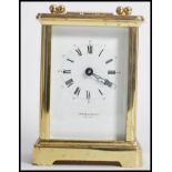 A vintage 20th century brass cased carriage clock with white dial and roman numeral chapter ring