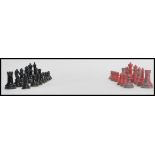 A vintage early 20th century chess set of lead construction consisting of red and black painted