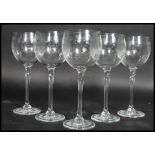 A set of six glass wine goblet glasses having a circular foot with split stem and engraved bowls