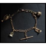 A hallmarked 9ct gold Albert style chain charm bracelet strung with three 9ct gold charms and one