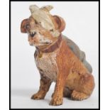 A 19th century  cold painted bronze pin cushion modelled as a wounded dog with bandage across eye.