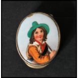 A silver and enamel hallmarked pill box of lozenge form, the enamel plaque with pictorial study of