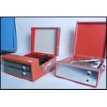 A pair of vintage 20th century portable record players, each having a vivid vinyl casing, carry