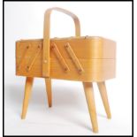 A vintage 20th century metamorphic sewing box raised on four tapering angular legs. Measures 41cms