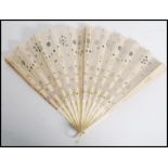 A 19th century engraved and fret pierced bone fan, with inset painted silk panels depicting Oriental