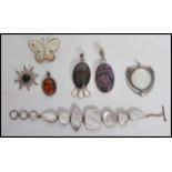 A group of sterling silver pendants to include filigree butterfly, amber drop, stone pendants,