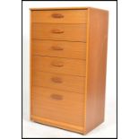 A retro mid century teak wood upright pedestal chest of drawers. Raised on castors with inset plinth