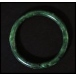 A Chinese carved jade bangle of plain circular form. Measures