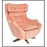 A 1960's Parker Knoll Statesman large batwing swivel egg chair - armchair being raised on a teak