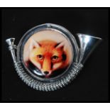 A sterling silver hunting brooch in the formof a hunting hron with enamel pictorial of a fox. Weighs