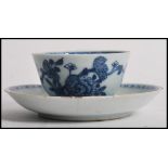 An 18th century Chinese blue and white tea bowl and saucer having hand painted scenes. Measures 12