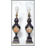 A pair of early 20th century cobalt blue ceramic table lamps in the manner of Sevres raised on a