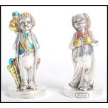 A pair of silver 925 clown figurines, each raised on plinth bases with coloured detailing. Stamped