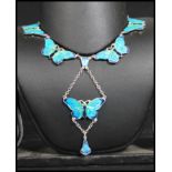 A sterling silver and enamel necklace chain having butterfly panels with butterflydrop. Weighs 23.