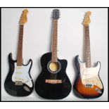 A group of three guitars one being a Music Fidelity acoustic guitar, an Encore coaster electric