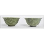 A pair of 19th century Chinese jade finger bowls having a mottled colour with circular foot.