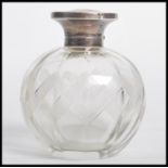 A silver topped faceted glass perfume scent bottle of bulbous form having an engraved wave