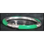 A sterling silver 925 stamped and jade bangle having a hidden clasp with safety chain.