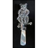 A sterling silver babies rattle in the form of a bear having a mother of pearl handle. Measures 9cms