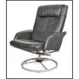 A retro style 20th century black leather swivel armchair being raised on a metal tubular base having