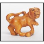 A Chinese carved netsuke in the form of a temple lion dog of Fu with signature to underside.