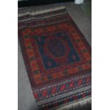 A Persian Islamic floor rug having a deep red and
