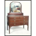 A vintage 20th century mahogany dressing table, fitted swing mirror over an arrangement of