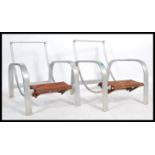 A pair of unusual mid century aluminium lounger chairs / armchairs of swept form having metal foot