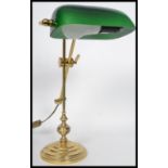 A vintage 20th century bankers desk lamp raised on an adjustable knopped column with stepped