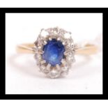 An 18ct gold diamond and sapphire ring. The central sapphire being prong set having a halo of