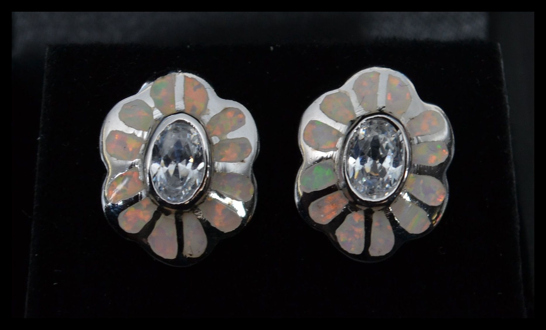 A pair of silver and enamel set stud earrings in the form of flowers having central white stones.