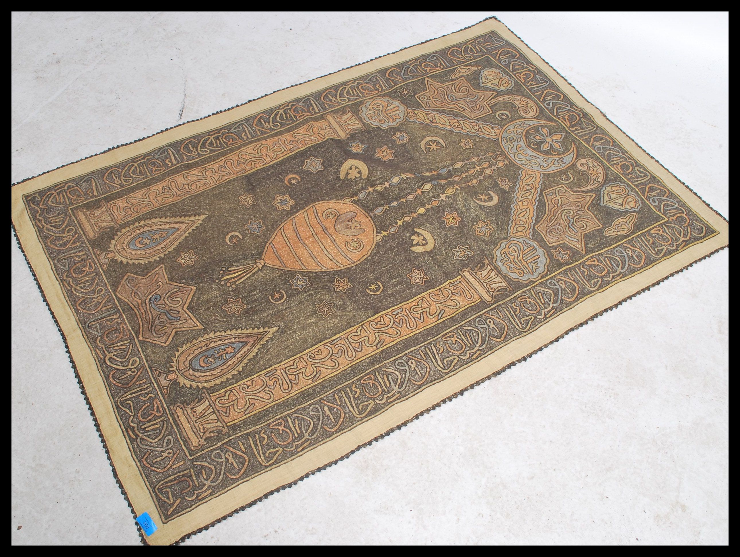 An unusual early 20th century Islamic hanging tapestry with geometric spandrels and borders having a