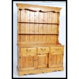 A 20th century large triple pine farmouse dresser in two parts. 3 cupboards and drawers to base,