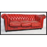 A contemporary 20th Century buttoned back  distressed red leather upholstered three seater