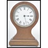 An early 20th century French mahogany inlaid balloon clock. Raised on a pedestal base with bun feet.