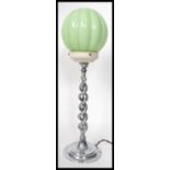 A vintage 20th century Art Deco chrome table lamp having a segmented green glass shade. The lamp