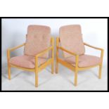 A pair of 20th century Ercol staff chairs. Light beech wood turned construction with shaped elbow